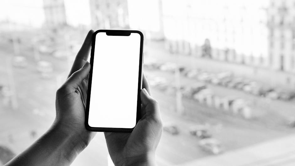 General Mobile 1 Nisan'da başlayan 5G şebekesine mobil ve geniş bant çözümleriyle hazır — Black and white image of hands holding a smartphone with a blank screen, outdoor