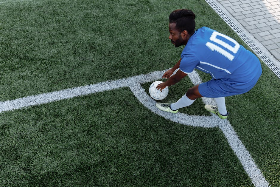 EA Sports FC 26'da Yapay Zeka Destekli Oyuncu Davranışları Geliştirildi — A soccer player in a blue jersey prepares to kick the ball from the corner on an